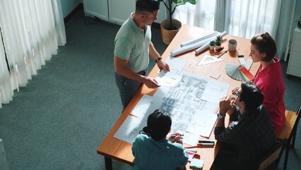Top view of interior designer planing building while project manager working and holding coffee....