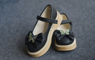 Girls' shiny black shoes on the carpet