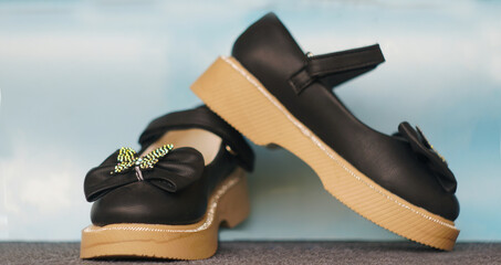 Girls' shiny black shoes on the carpet