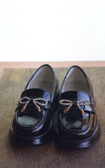 Girls' shiny black shoes on the carpet