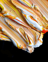 Abstract acrylic Paint Swirl in Yellow, orange and White on Black Background