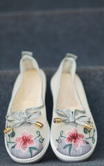 Girls' shoes in floral fabric on the carpet