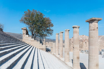 Timeless stone steps ascend into the clarity of Mediterranean light, where weathered columns echo...