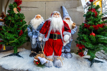 Festively decorated Santa figures between Christmas trees in the old town of Lindau, Bodensee, Germany