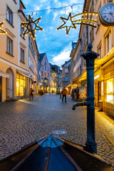 Christmas atmosphere in Lindau’s historic old town on Lake Constance. The pedestrian street is festively decorated with glowing stars and warm lights.