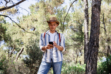 Young tourist exploring forest with smartphone