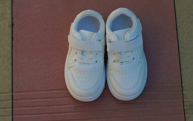 White sneakers on the ground in nature