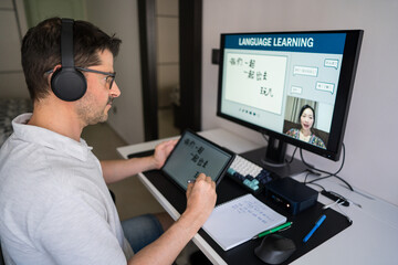 Man studying mandarin online from home