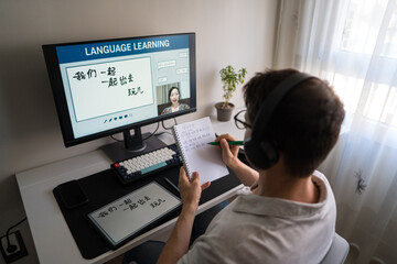 Man learning Mandarin online at home with computer