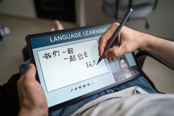 Man learning Mandarin online at home using tablet