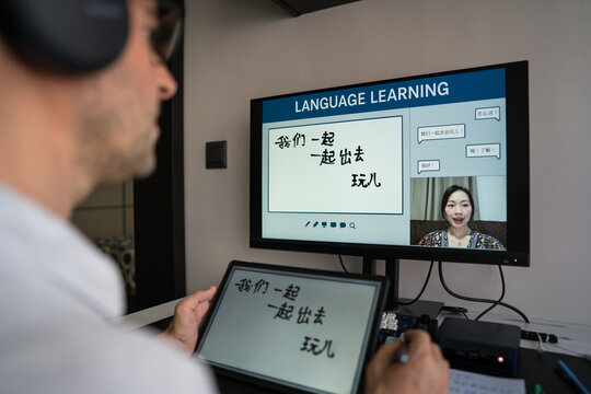 Man learning mandarin online at home with tablet