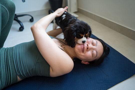 Young woman exercising with playful dog interruption