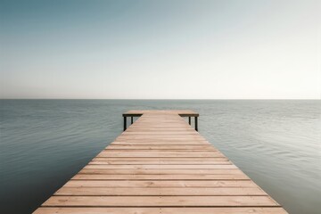 Fototapeta premium Wooden pier extending into calm ocean under a vast serene sky