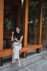 Excited businesswoman celebrating success while reading good news on smartphone in outdoor cafe