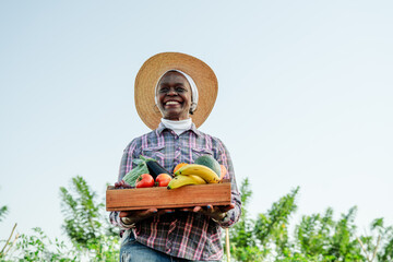 Happy Farmer Holding Fresh Harvested Vegetables and Fruits Outdoors