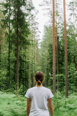 Back View of Woman Hiking Through a Lush Green Fern Forest in Summer
