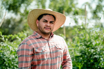 Portrait of Confident Farmer in Straw Hat Amidst Lush Greenery