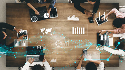 Aerial view of a diverse team collaborating on various digital devices, showcasing data analytics...
