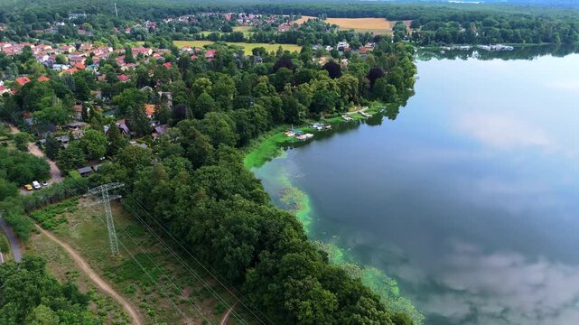 Schwielowsee lake near Potsdam, Germany,. Aerial view captures serene lake surrounded by lush greenery and vibrant landscapes, showcasing the tranquil beauty of nature in a continuous motion sequence