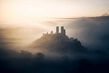 Obraz premium Corfe Castle on a moody foggy sunrise morning 