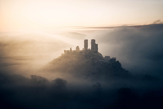Corfe Castle on a moody foggy sunrise morning 