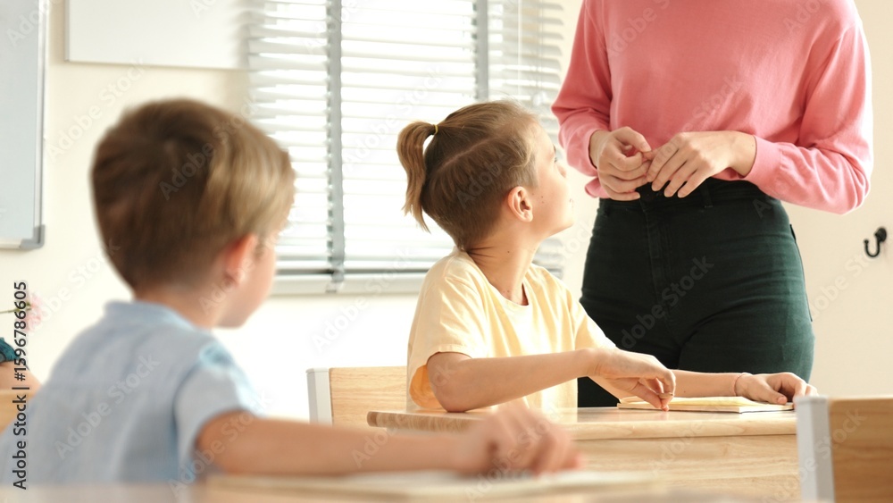 Poster beautiful teacher explaining test while caucasian boy doing classwork and listening explanation. cut