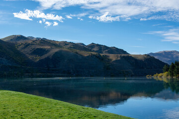 Serene Lake Landscape with Mountains and Blue Sky