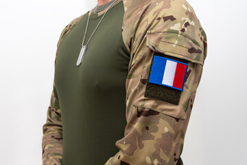 Fototapeta premium French soldier in tactical clothing with camouflage sleeves and metal badges.