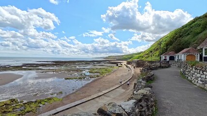 Traditional beach huts on Scarborough South Bay on the North Yorkshire coast. Panning shot