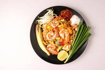 Stir fried thai noodles with shrimps ,Pad Thai in black plate on white background