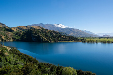 Serene Lake Surrounded by Mountains and Greenery