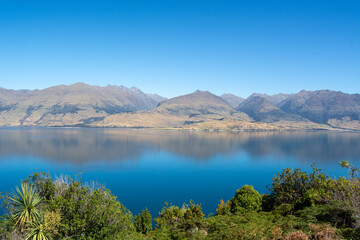 Tranquil Lake and Mountain Reflection Under Clear Blue Sky
