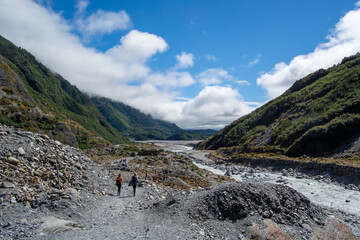 Fototapeta premium Hikers Exploring a Scenic Rocky Riverbed