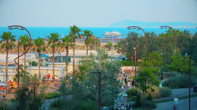 Aerial view of large equipped sandy beaches. Umbrellas and sun loungers for vacationers by the sea. Vacation on the Adriatic Sea. Ferris wheel. Traveling on Europe. Vacation in Italy Rimini 21.07.2025