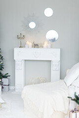 Bright interior with a false fireplace decorated for Christmas. Christmas trees with garlands, balloons and lights.