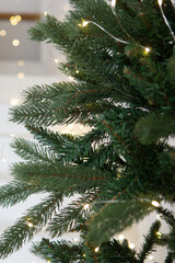 A large Christmas tree in the living room, decorated with garlands and light balloons. Bright...