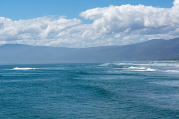 Serene Coastal View with Gentle Waves and Blue Sky