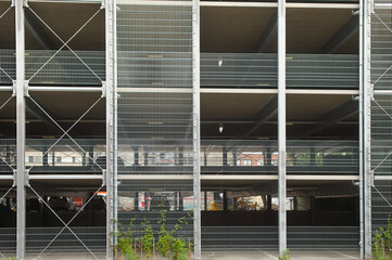 Modern parking garage showing steel structure and wire mesh facade