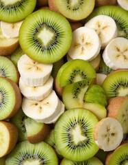 Fresh fruit stand with vibrant kiwi, white banana, red apple, and green pear slices. Haphazard arrangement creates visually dynamic display. Colorful fruit variety adds to appetizing presentation.