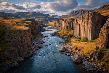 Canyon river flowing between basalt cliffs at sunset