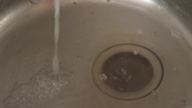 clogged kitchen sink, water and food debris in clogged kitchen sink drain, plumbing problem in home in everyday life