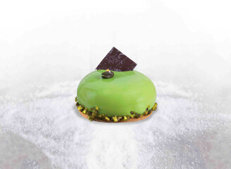 Pistachio Mousse Cake with Glossy Glaze and Chocolate Garnish isolated on white background side...