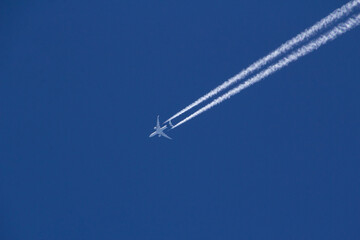 Condensation trails from an airplane in the blue sky