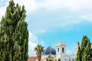 Spanish Church with Blue Dome and White Bell Towers Framed by Trees