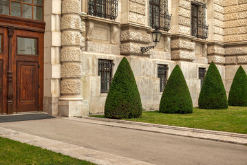 Topiary garden with historic Hofburg Palace wall
