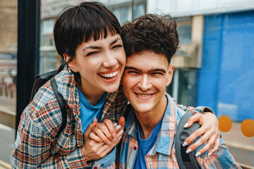 Young couple enjoying a happy moment together in a vibrant urban setting on a sunny day, capturing their joy and connection