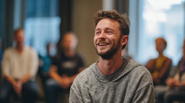Young happy man after his self presentation on a group psychotherapy, no logos, no brands