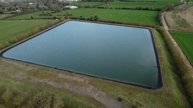 Vid&eacute;o a&eacute;rienne d'une bassine, r&eacute;servoir artificiel charg&eacute; en eau en hiver et utilis&eacute; pour l'arrosage en &eacute;t&eacute;.