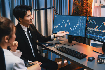 Asian businessman showing dynamic stock exchange currency rate statistic online to share with...