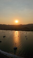 Sunset coastal city. Boats coastal town. Coastal mountain landscape, sea resort yachts, golden hour